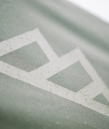 Close up image of water droplets from rain on a green canopy tent roof. 